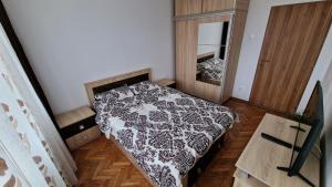 a bedroom with a black and white bed and a mirror at MMT SweetHome 1 in Ploieşti