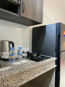 a kitchen counter with a stove and some water bottles at Appart hôtel in Nouakchott