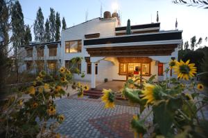 una casa con girasoli davanti di Hotel DZI Ladakh a Leh