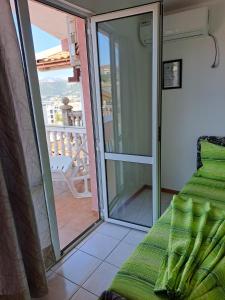 Zimmer mit einer Glastür, die auf einen Balkon führt. in der Unterkunft Apartmani Family in Dobra Voda