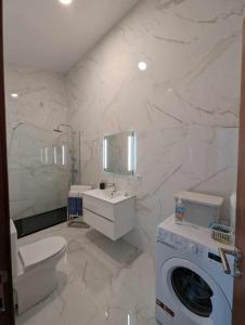 a bathroom with a toilet sink and a washing machine at Oceanus in Faja Grande