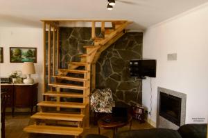 a wooden staircase in a living room with a stone wall at O sexto in Sintra