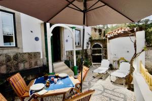 a patio with a table and an umbrella at O sexto in Sintra