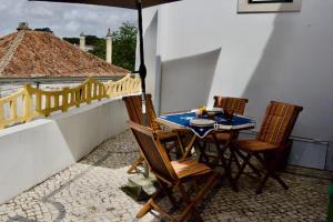 einen Tisch und Stühle auf einem Balkon mit Sonnenschirm in der Unterkunft O sexto in Sintra