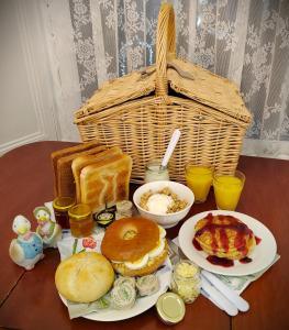 a table with breakfast foods and a basket on it at Puddle Duck Lodge – Adults Only in Bowness-on-Windermere