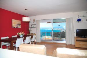 a living room with a dining room table and a television at UHC Bahia Family Complex in Salou
