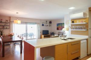 a kitchen with a counter and a dining room with a table at UHC Bahia Family Complex in Salou +15 photos