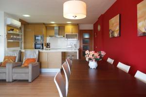a dining room table with a vase of flowers on it at UHC Bahia Family Complex in Salou
