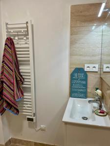 a bathroom with a sink and a sign on the wall at Gîte Ensemont in Saramon