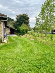a field of green grass next to a house at Gîte Ensemont in Saramon +12 photos