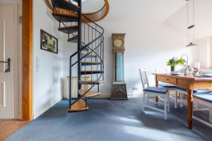 a spiral staircase in a room with a table and a clock at App Tagesschau in List