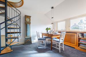 a dining room with a table and chairs and a clock at App Tagesschau in List