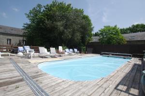 a large swimming pool with chairs and a table at chambre zen in Condé-sur-Noireau +11 photos