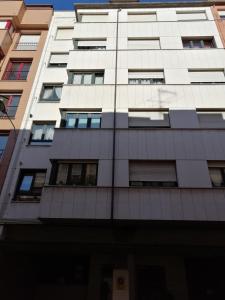 a tall white building with windows at Zona centro con plaza de garaje VUT3983AS in Gijón