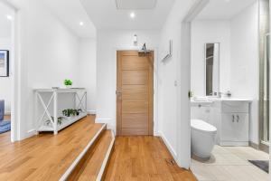 a bathroom with a toilet and a wooden door at 1 Bedroom Apartment Near Heathrow London - TW18 in Staines