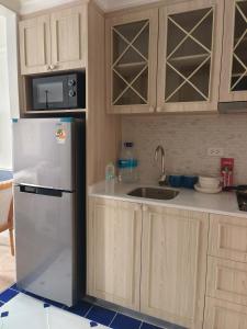 a kitchen with a refrigerator and a sink at 七星海景公寓 in Bang Sare