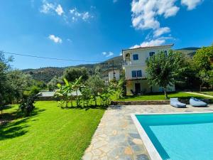 a villa with a swimming pool and a house at Cottage & private swimming pool in Poros