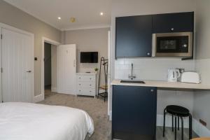 a bedroom with a bed and a kitchen with a sink at 5 The Cuckmere in Seaford