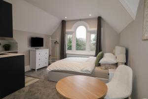 a bedroom with a bed and a table and a window at 8 The Cuckmere in Seaford