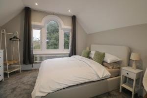 a bedroom with a large bed and two windows at 8 The Cuckmere in Seaford