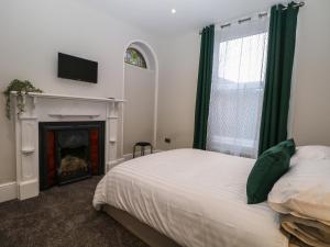 a bedroom with a bed and a fireplace and a television at 1 The Charleston in Seaford