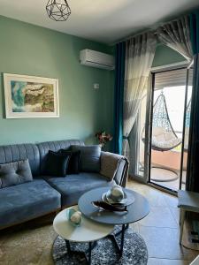 a living room with a blue couch and a table at Beach front apartment in Vlorë