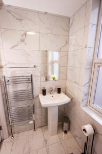 Baño blanco con lavabo y espejo en Two Bedroom Luxury RB Home en Stalybridge