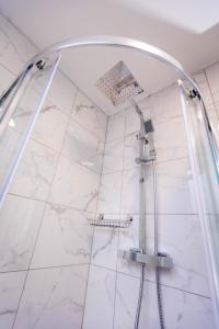 a shower in a bathroom with white marble at Two Bedroom Luxury RB Home in Stalybridge