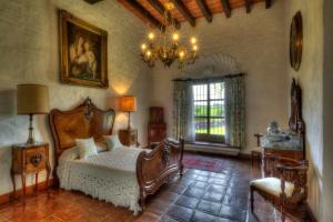 a bedroom with a bed and a chandelier at Hacienda Acamilpa in Acamilpa