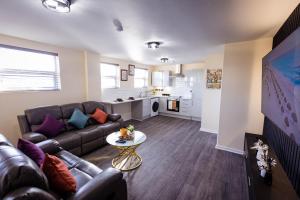 uma sala de estar com um sofá e uma mesa em Two Bedroom Luxury RB Home em Stalybridge