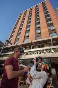 un gruppo di persone che si trovano di fronte a un edificio di Garden Plaza a San Miguel de Tucumán