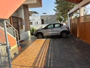 mały samochód zaparkowany obok budynku w obiekcie 2 BHK Villa for Class & Mass of 8-10 Decent people w mieście Mysuru