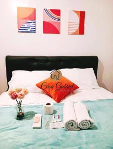 un letto con asciugamani e un cuscino rosso sopra di Casa Gabriel in Marilao a Marilao