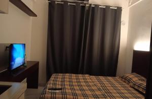 Cilenggangにあるapartemen sky house bsdのベッドルーム1室(ベッド1台、黒いカーテン付)