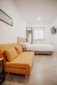 Zaratán的住宿－Polorooms，一间带两张床和一张沙发的客厅