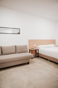 sala de estar con 2 camas y sofá en Polorooms, en Zaratán