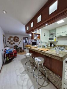 uma cozinha com um balcão e bancos num quarto em Recanto Maravista apto Frente Mar 2 quartos em Vila Velha