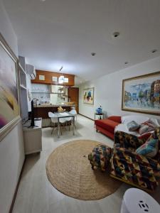 uma sala de estar com um sofá vermelho e uma mesa em Recanto Maravista apto Frente Mar 2 quartos em Vila Velha