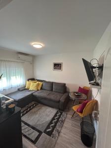 uma sala de estar com um sofá e uma mesa em Villa 46 - little heaven em Banja Luka