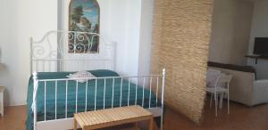 a room with a crib with a table and a couch at Casa Vacanza Cascina Ronco relax nella natura vicino a Como e Bellagio in Erba