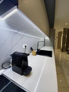 a white counter top with a black appliance on it at Suncity Tirana Luxury Apartments (Ap. 01) in Tirana