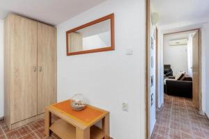 a living room with a table and a mirror on the wall at Apartments Ivo Bozinovic in Tivat
