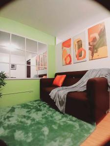 un soggiorno con letto e tappeto verde di Casa Gabriel in Marilao a Marilao
