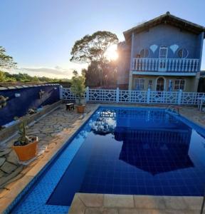Villa con piscina frente a una casa en Lugar de Ser Feliz Casa da Jô, en Saquarema