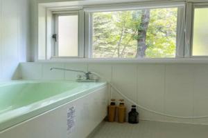 ein Bad mit einer Badewanne und einem Fenster in der Unterkunft Kitakaruizawa Morino Bessou NO4 in Tsumagoi