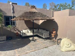 a patio with a couch under an umbrella at Villa B à 5km du centre in Marrakech