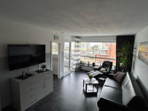 a living room with a couch and a flat screen tv at Frische Brise Ferienwohnung mit Meerblick in Cuxhaven