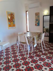 einen Tisch und Stühle in einem Raum mit gemustertem Boden in der Unterkunft Holiday Home Recanati in Giardini-Naxos + 21 Fotos