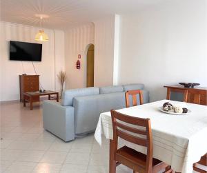 a living room with a table and a couch at Mare Nostrum in Armação de Pêra