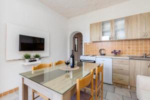 a kitchen with a table and chairs and a counter top at Apartments Ivo Bozinovic in Tivat